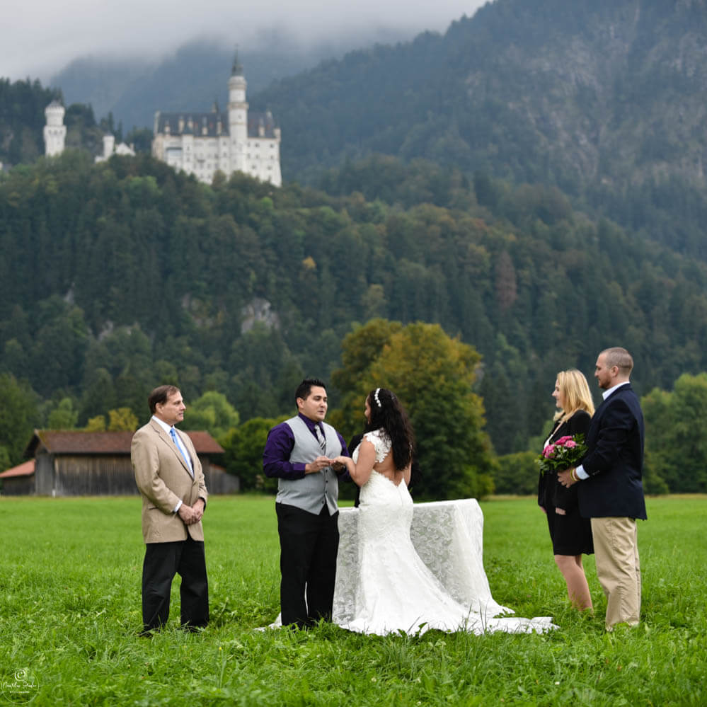 Photo shows couple below Neuschwanstein Castle at their ceremony