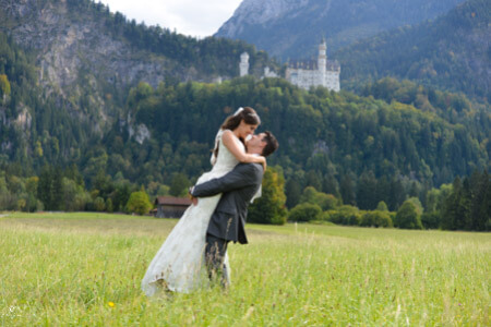 Wedding in Germany at Neuschwanstein Castle, photo of bride and groom below the castle